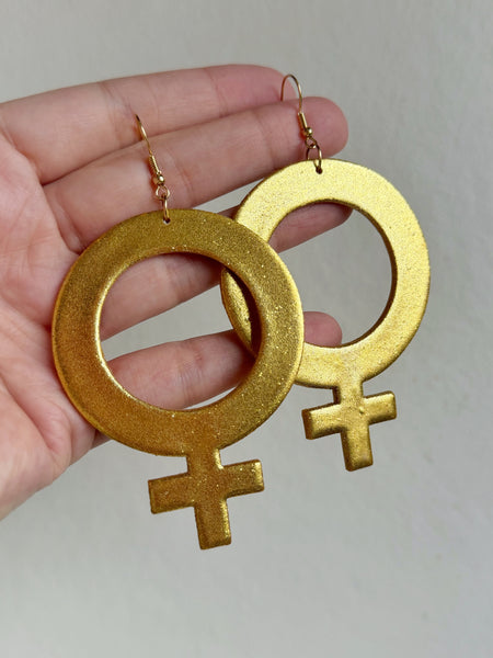 Stora kvinnotecken, örhängen guldiga