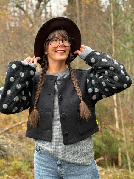 Kort jacka i svart ull med prickiga ärmar
