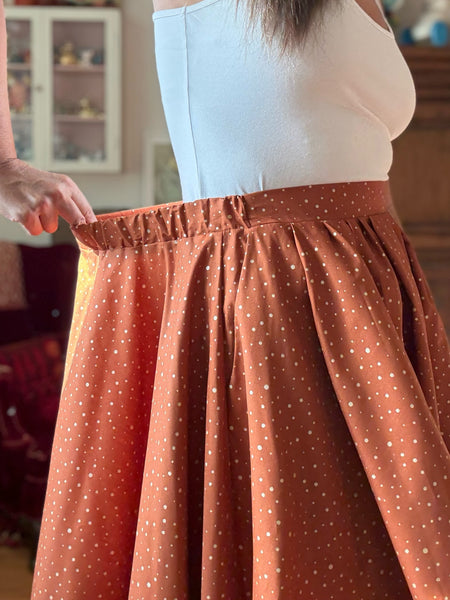 Vid kjol i tegelfärgad bomull med guldprickar