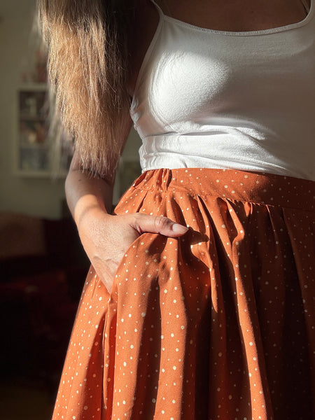 Vid kjol i tegelfärgad bomull med guldprickar