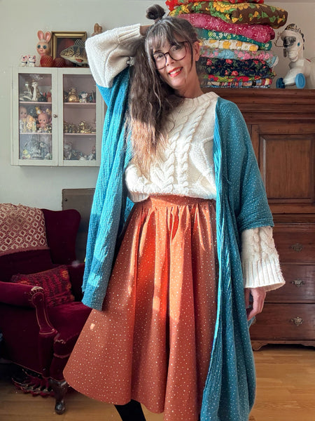 Vid kjol i tegelfärgad bomull med guldprickar