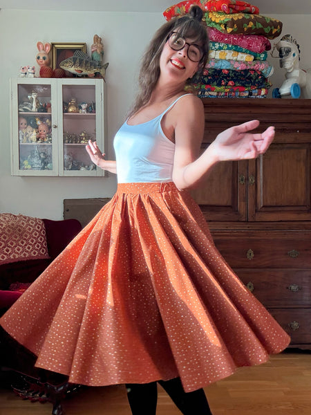 Vid kjol i tegelfärgad bomull med guldprickar