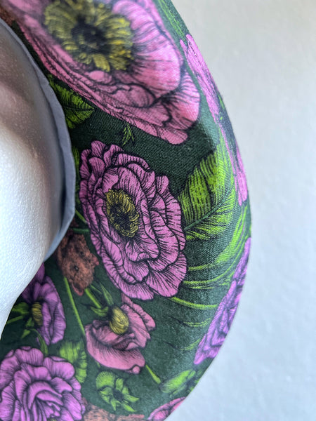 Solhatt i svart linne med rosa blommor