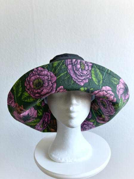 Solhatt i svart linne med rosa blommor